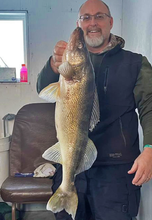 image of ice fisherman at River Bend Resort holding huge walleye